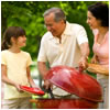 A family gathers in front of an outdoor grill